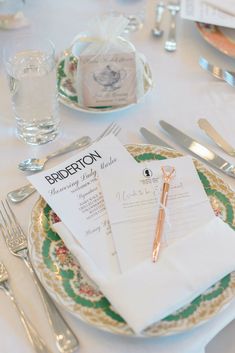 the table is set with silverware and place settings