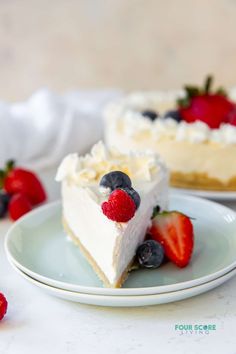 a slice of cheesecake with fresh berries on the plate and another piece in the background