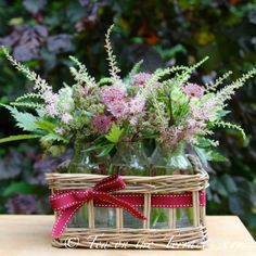 a basket filled with flowers sitting on top of a wooden table