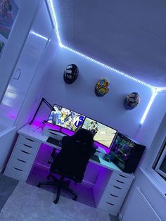 a computer desk with two monitors on it in a room that has white walls and purple lighting