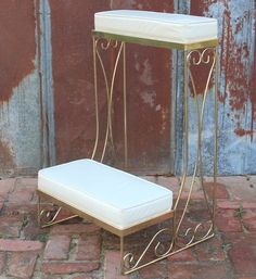 a white bench sitting on top of a brick floor