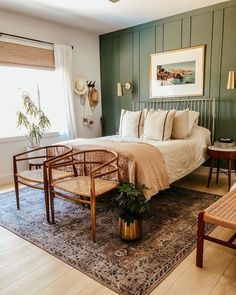 a bedroom with green painted walls and wooden furniture, including a large bed in the center