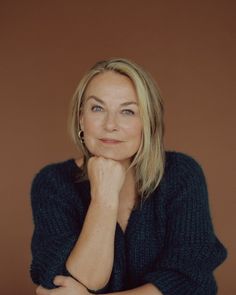 a woman is posing for a photo with her hand on her chin and looking at the camera