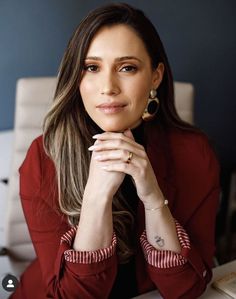 a woman sitting at a desk with her hand on her chin and looking off to the side