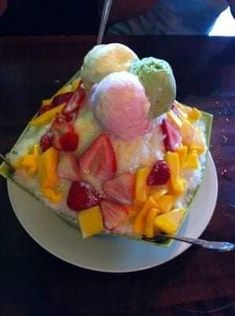 a piece of cake with fruit and ice cream on top