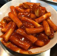 a white plate topped with hot dogs covered in sauce