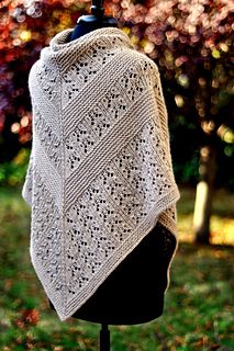 a white knitted shawl on a mannequin in front of a tree