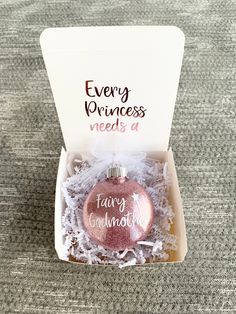 a pink ornament sitting in a box on top of a carpeted floor