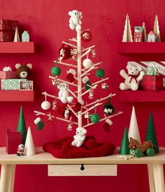 a small christmas tree with teddy bears and other ornaments on the shelf next to it