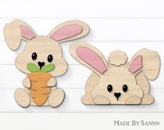 two wooden cutouts of rabbits holding a carrot