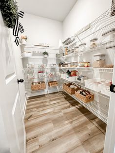 an organized pantry with lots of shelves and baskets