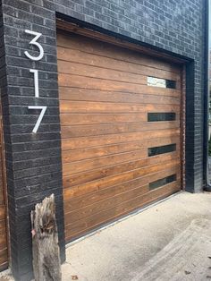 a wooden garage door on the side of a brick building