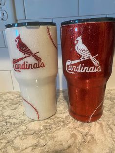 two red and white tumblers sitting on top of a counter