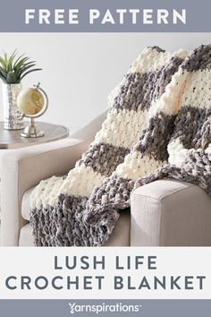 a crocheted blanket sitting on top of a couch next to a coffee table