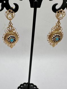 A unique opportunity for a wonderful pair of vintage 14K yellow gold dangle earrings. These unique earrings are hallmarked 14K on the bottom dangle and are guaranteed to be such. These gorgeous earrings have 2 dangles. The top dangle looks like a circle, which houses a 3.3mm pearl and what looks to be a crown. The bottom dangle features an elaborate design with a center blue stone, perhaps a tourquoise? The intricacy of the design is impressive. These are post earrings with butterfly closures. These beauties are 2 3/4" long and just under 3/4" at their widest. They are an impressive 6.31 grams. These are fabulous pair of earrings and perfect for a special occasion or for that person who just wants some thing very different! Antique Yellow Gold Drop Earrings, Victorian Yellow Gold Drop Earrings, Antique 14k Gold Hallmarked Earrings, Victorian 14k Gold Earrings, Victorian Gold Plug Earrings, Vintage 14k Gold Filigree Earrings, Ornate 14k Gold Earrings, Victorian 14k Gold Filigree Earrings, Victorian 14k Gold Round Earrings