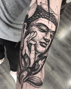 a person with a tattoo on their arm that has an image of a buddha head