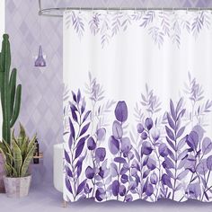 a shower curtain with purple flowers on it next to a potted cacti