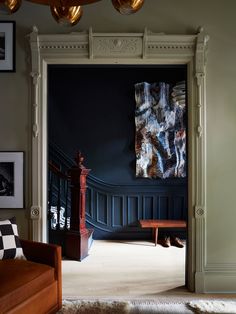 an open door leading to a living room with blue walls and wooden furniture in it