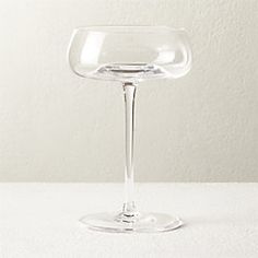 an empty wine glass sitting on top of a white countertop next to a wall