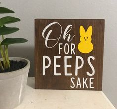 a wooden sign that says oh for peeps sake next to a potted plant