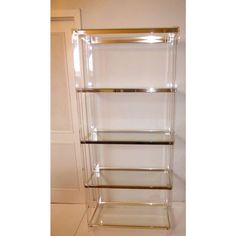 three tiered glass shelving unit with gold trim