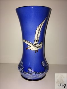 a blue vase with a bird painted on it