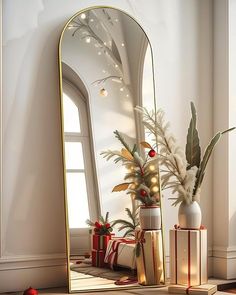 a large mirror sitting on top of a table next to a vase filled with plants