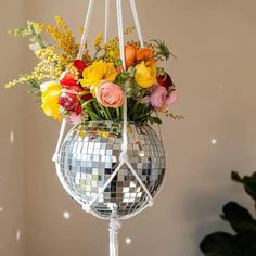 a mirror ball hanging from the ceiling with flowers in it