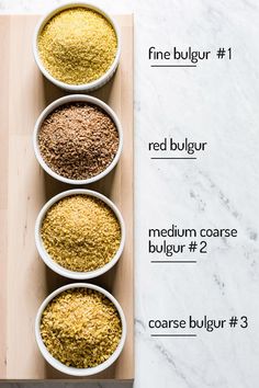 three bowls filled with different types of spices on top of a wooden board next to each other