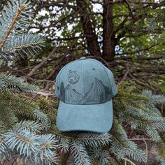 This wood burned green faux suede baseball cap would make a great addition to any nature lover's wardrobe. I hand burnt a mountain range around the entire crown of the hat with pine trees growing along it using a pyrography tool and a freehanded original design. Then, for a unique finishing touch I burnt a full moon with craters and stars in the sky above the landscape. Materials: 100% cotton Hat fits most with an adjustable buckle in the back *Disclaimer* colors may vary slightly from screen to Moon Hat, Pyrography Tools, Outdoorsy Gifts, Celestial Gifts, Stars In The Sky, Hand Burn, Hat Fits, Dad Cap, Landscape Materials