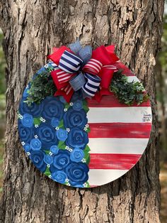 a patriotic wreath hanging on the side of a tree