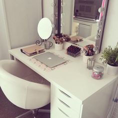 a white desk topped with a laptop computer next to a mirror and potted plant