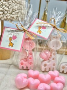 some pink and white candies are in plastic bags on a table with other items