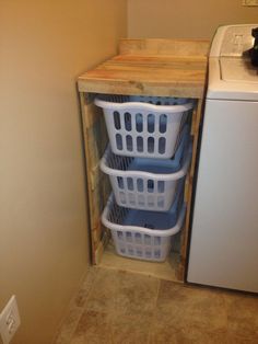 three laundry baskets are stacked in front of the washer and dryer