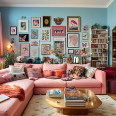 a living room filled with pink furniture and pictures on the wall above it's coffee table