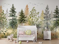 a baby's room with trees and birds painted on the wall, including a crib