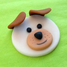 a close up of a cake shaped like a dog's head on a green surface