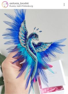 a hand holding a blue and white bird ornament