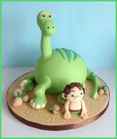 a green cake with a boy and a dinosaur on it