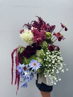 a woman holding a bouquet of flowers in her hands