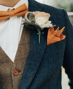 a man in a suit and bow tie with a boutonniere on his lapel