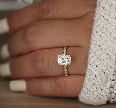 a woman's hand with a diamond ring on it