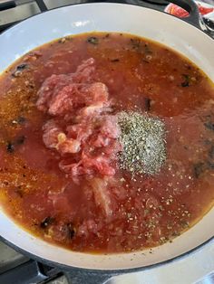 a bowl filled with meat and spices on top of a stove