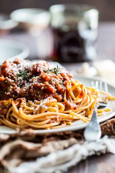 a plate of spaghetti with meat sauce and parmesan cheese