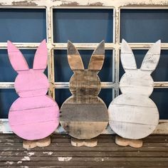 three wooden easter bunnies sitting next to each other