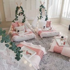 a bedroom with pink and white bedding, pillows and blankets on top of a rug