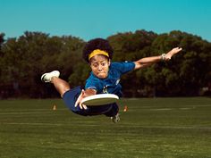 a person jumping up in the air to catch a frisbee on a field