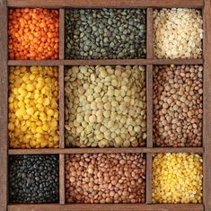 an open wooden box filled with different colored beans