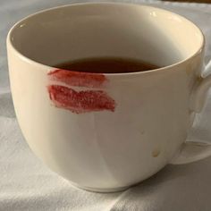 a white cup filled with liquid on top of a table