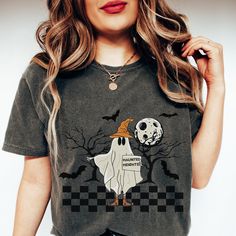 Calling all daring souls and Halloween enthusiasts! Embrace the hilariously haunting vibes of the season with our 'Haunted Heights' Funny Halloween Shirt. Picture this: a mischievous hitchhiking ghost, decked out in retro style, holding a sign that promises thrills and chills. You know you're in for a spooktacular adventure! But beware, dear traveler, this is no ordinary ghost! With a dash of cuteness and a pinch of mischief, our Hitchhiking Ghost Shirt guarantees to bring smiles and laughter wh Witchy Halloween T-shirt With Graphic Print, Horror Themed Short Sleeve T-shirt For Fall, Halloween Horror Cotton T-shirt, Fall Witchy Graphic Print T-shirt, Spooky Halloween Tops With Funny Print, Spooky Halloween Shirt With Letter Print, Spooky Custom Print Halloween T-shirt, Witchy Halloween Crew Neck T-shirt, Spooky Graphic Print Shirt For Halloween